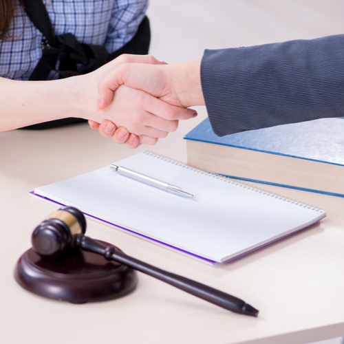 This is an image of an injured person shaking hands with their lawyer after starting the workers' compensation claims process in Atlanta