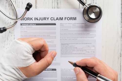 Injured person fills out a claim form for workers compensation benefits in Douglasville