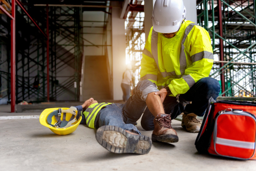 This is an image of an injured construction worker being tended to by a fellow construction worker before filing compensable work injuries in Loganville 