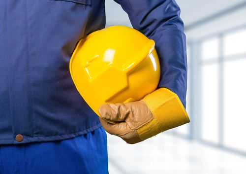 Image is of a man holding a yellow construction helmet after speaking to a Marietta workers' compensation lawyer